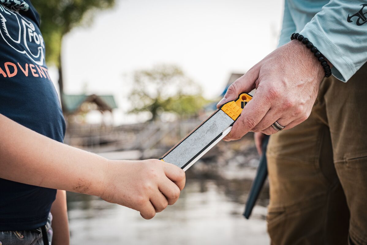 A fathers gifting his son his first sharpener on a fishing trip