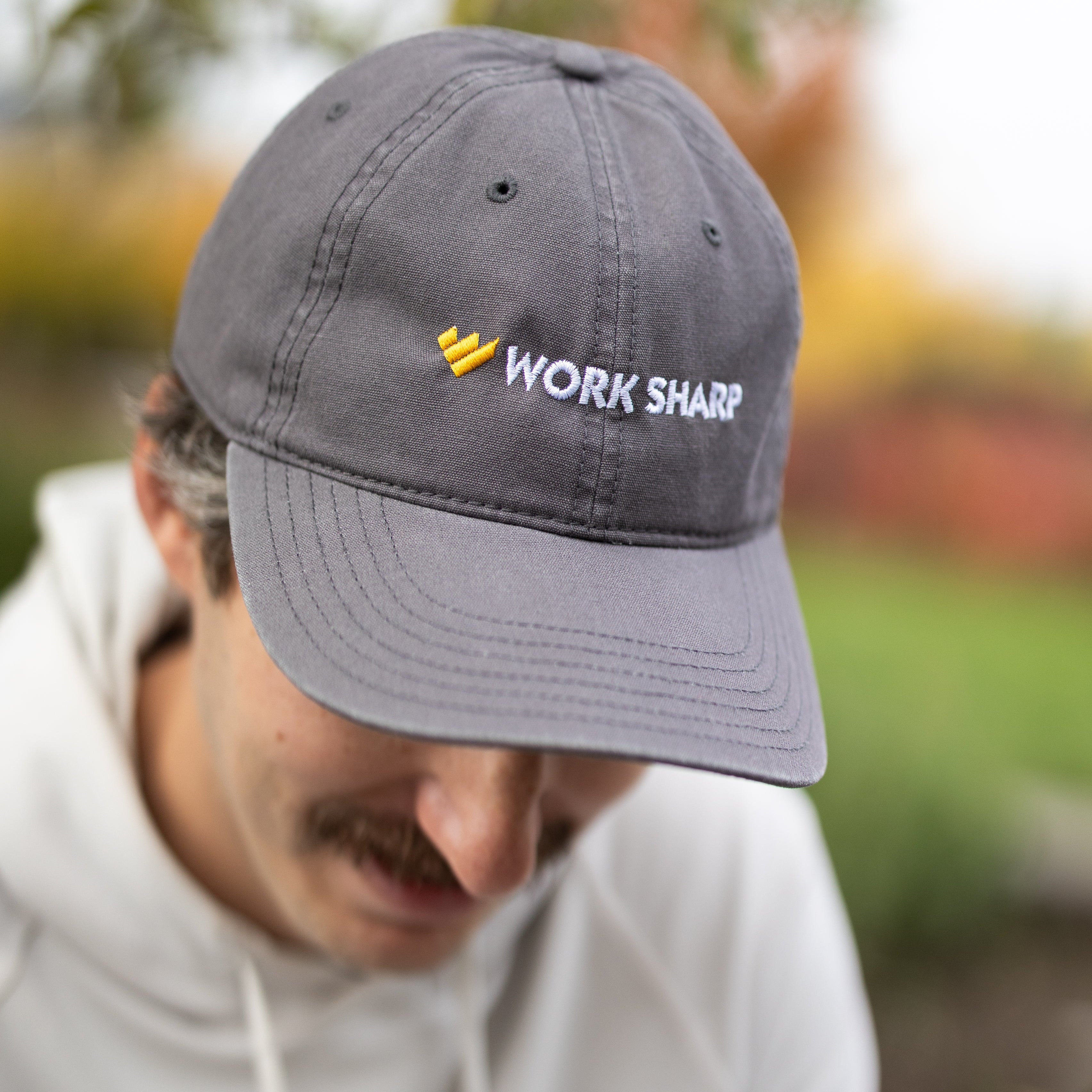 Person wearing a gray cap with 'Work Sharp' logo outdoors