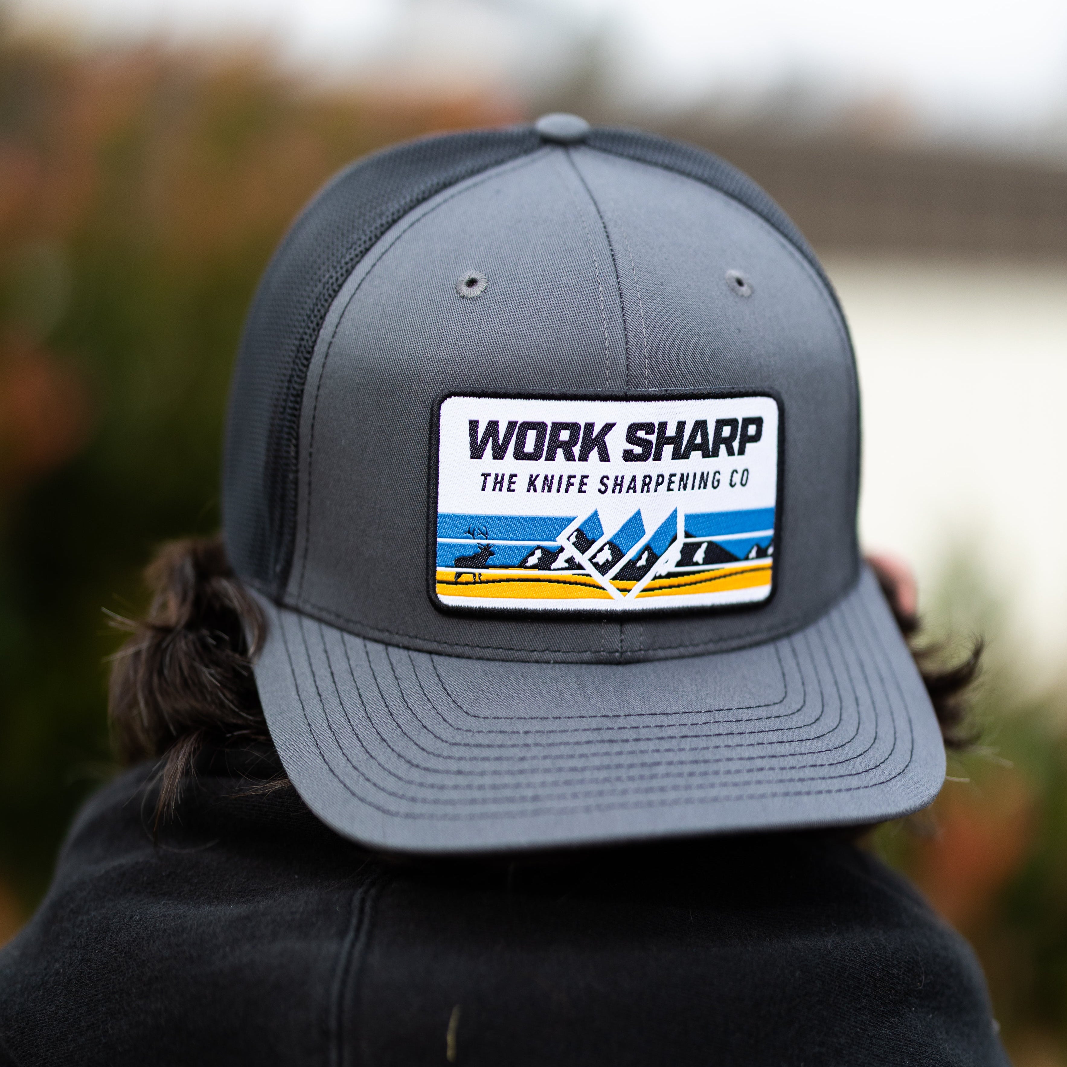 Gray cap with Work Sharp logo worn by a person outdoors