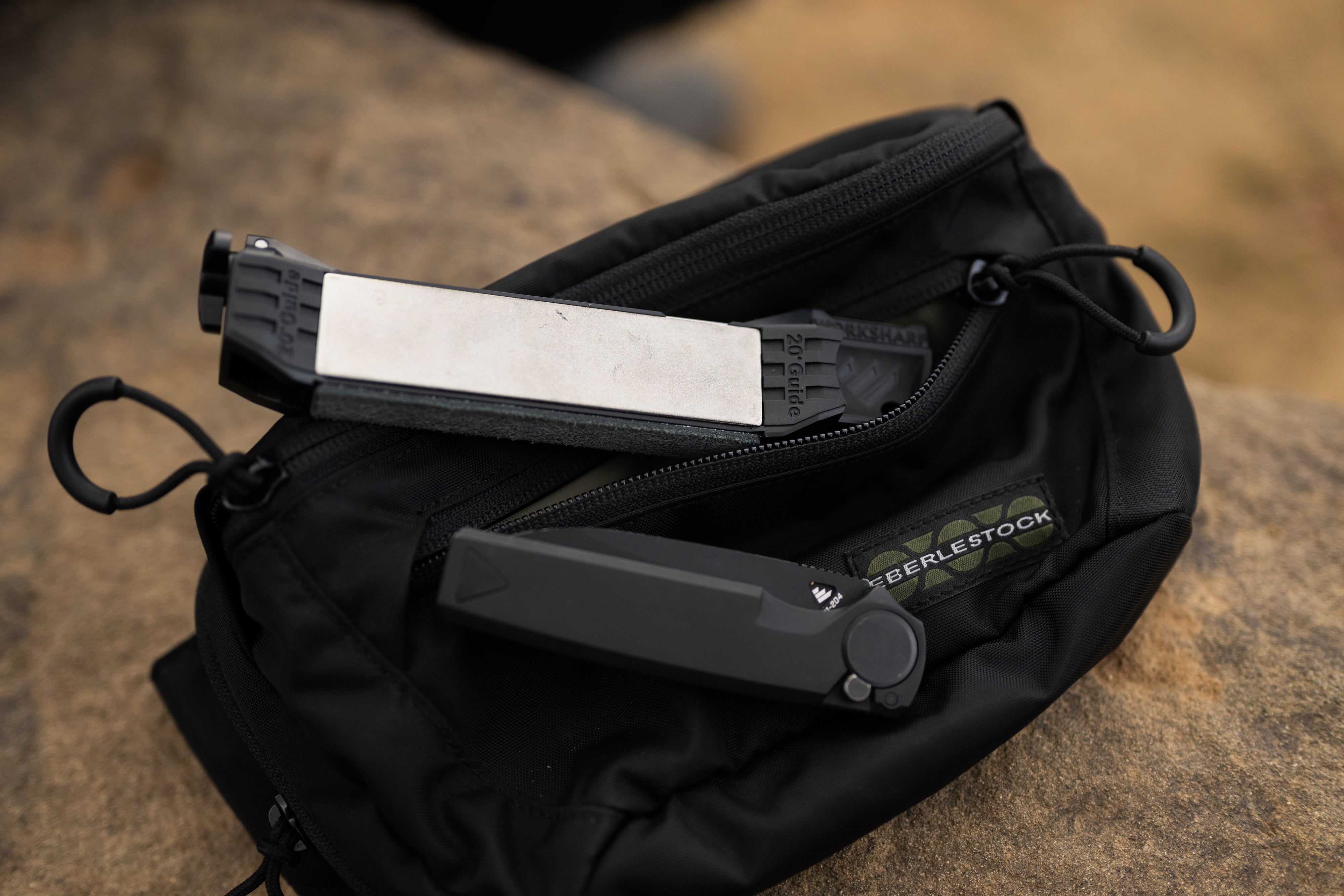 Guided Field Sharpener Blackout | Reserve Series on a black pouch against a blurred natural background